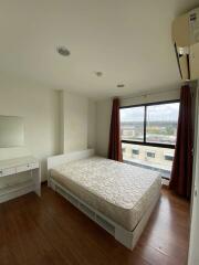 Simple bedroom with large window and wooden floor