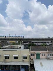 View of train passing behind residential buildings