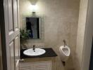 Modern bathroom with sink, mirror, and urinal