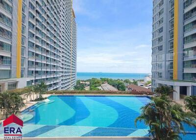 View of residential buildings with a pool and ocean in the background