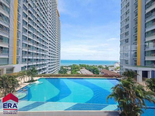 View of residential buildings with a pool and ocean in the background