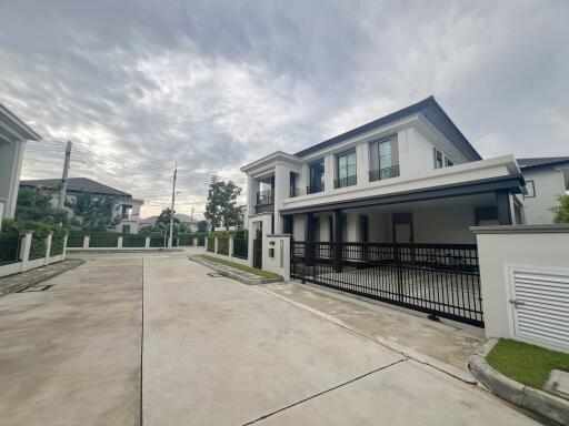 Modern two-story house with a gated driveway in a residential neighborhood