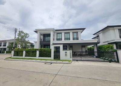 Modern two-story house exterior with driveway and greenery