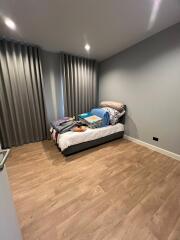 Modern bedroom with wooden flooring and curtains