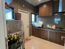 Modern kitchen with wooden cabinetry, stainless steel appliances, and a storage cart