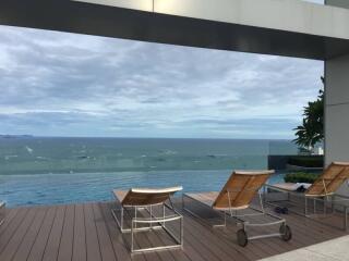 Outdoor terrace facing ocean with sun loungers