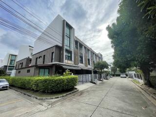 Photo of modern townhouses with a covered car park area and greenery