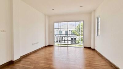 Bright and spacious living area with wooden flooring and large windows