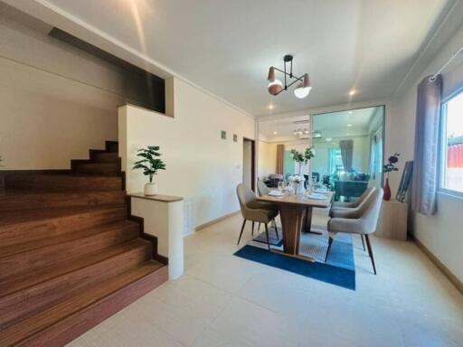 Modern dining area with adjacent stairs and large mirror