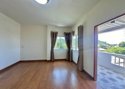 Spacious bedroom with large windows and connected balcony