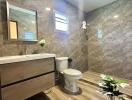 Modern bathroom with marble tiles and wooden vanity