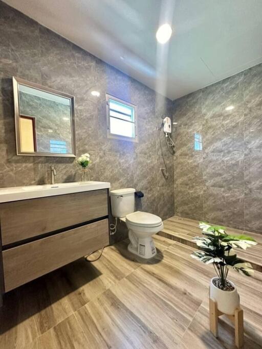 Modern bathroom with marble tiles and wooden vanity
