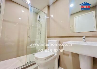 Modern bathroom with glass shower, toilet, and sink