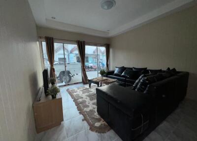 Living room with black leather sectional sofa and large window