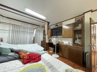 Bedroom with wooden furniture and well-lit ceiling