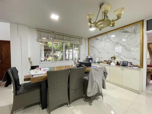 Home office with a large desk, chairs, and wall decorations