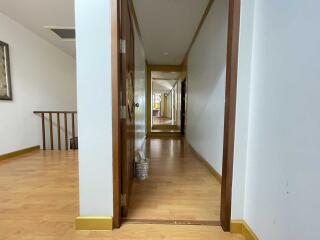 Well-lit hallway with wooden flooring