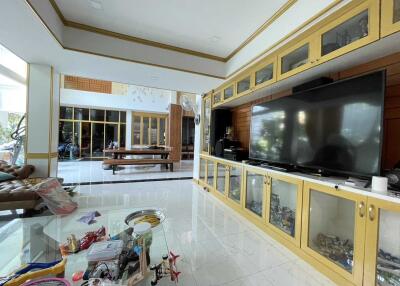 Spacious living room with large TV and glass cabinets