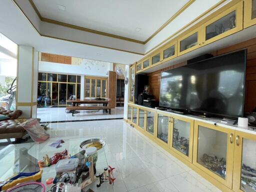 Spacious living room with large TV and glass cabinets