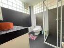 Modern bathroom with glass shower and black accents