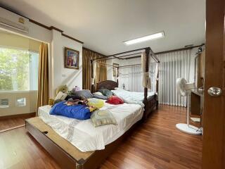 Spacious bedroom with a wooden canopy bed and large window