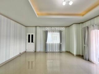 Empty living room with tiled floor and large windows