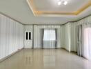 Empty living room with tiled floor and large windows