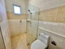 Bright modern bathroom with a glass shower and toilet