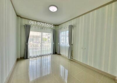 Well-lit living room with large windows and curtains