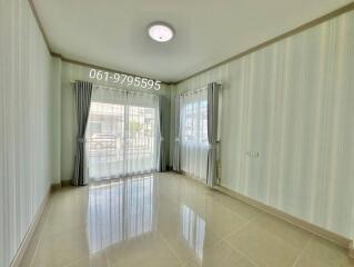 Well-lit living room with large windows and curtains