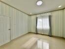 Empty bedroom with tiled floor and striped wallpaper