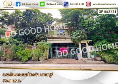 Front view of a house with greenery and a gated entrance