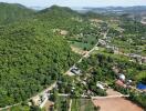 Aerial view of a lush green hilly area with scattered residential properties