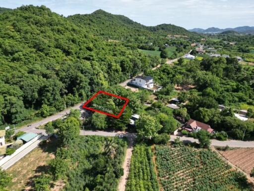 Aerial view of property surrounded by lush greenery and hills