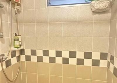 Shower area with tiled wall and window