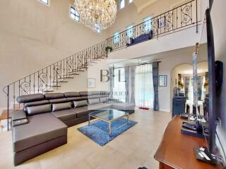 Spacious living room with a large sectional sofa and chandelier