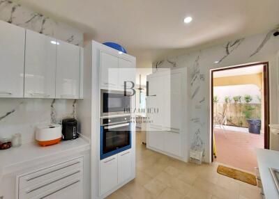 Modern kitchen with white cabinetry and marble backsplash