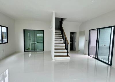 Main living space with staircase and large windows