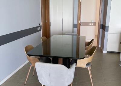 Modern dining area with glass table and wooden chairs