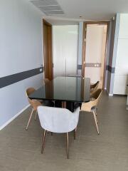 Modern dining area with glass table and wooden chairs