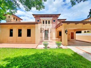 Exterior view of a large, Mediterranean-style house with well-maintained landscaping