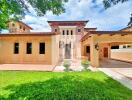 Exterior view of a large, Mediterranean-style house with well-maintained landscaping