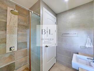 Modern bathroom with shower, sink, and tiled walls