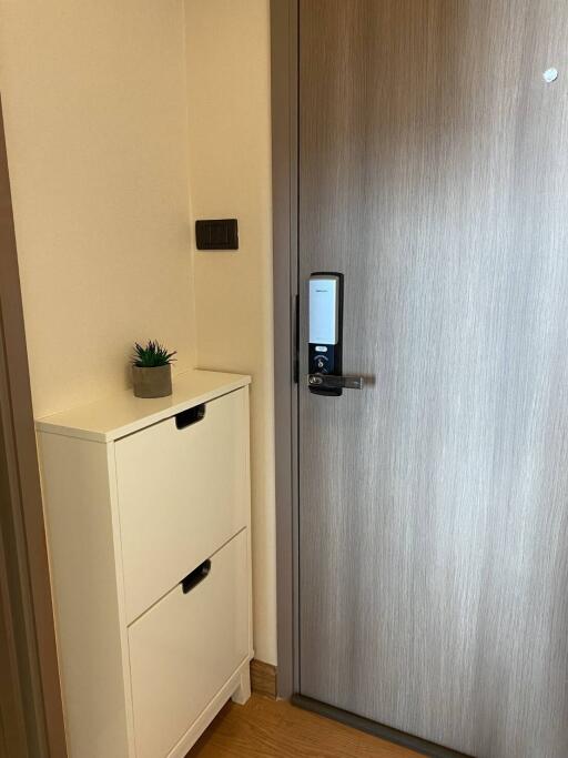 Modern apartment entrance with electronic lock and shoe cabinet