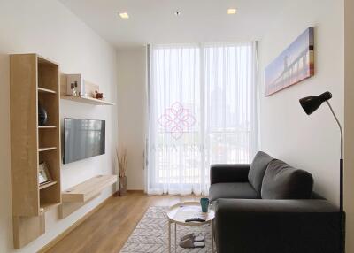 Modern living room with sofa, wall-mounted TV, and shelves