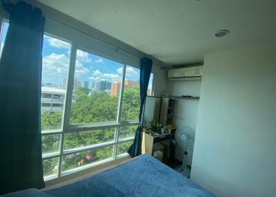 Bedroom with large window and view of the city