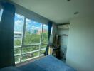 Bedroom with large window and view of the city