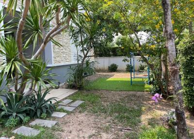 Well-maintained garden area with landscaping and a playset