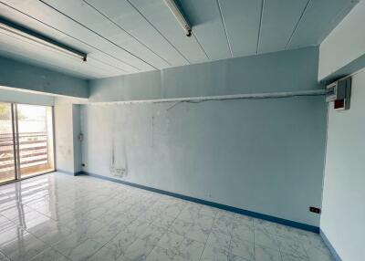 Spacious empty room with tiled floor and large window