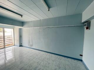 Spacious empty room with tiled floor and large window